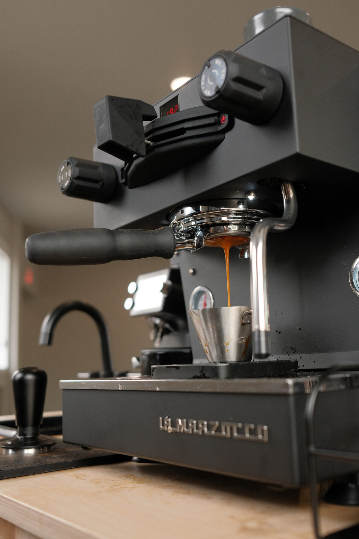 An espresso shot pulling into a cup at the counter