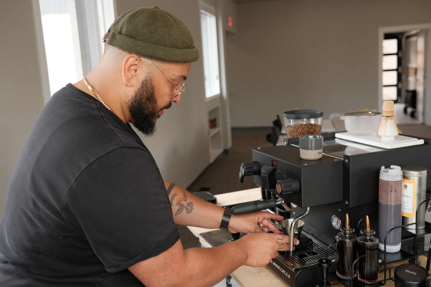 Nathan pulling a shot at the espresso machine, steam rising from the group head