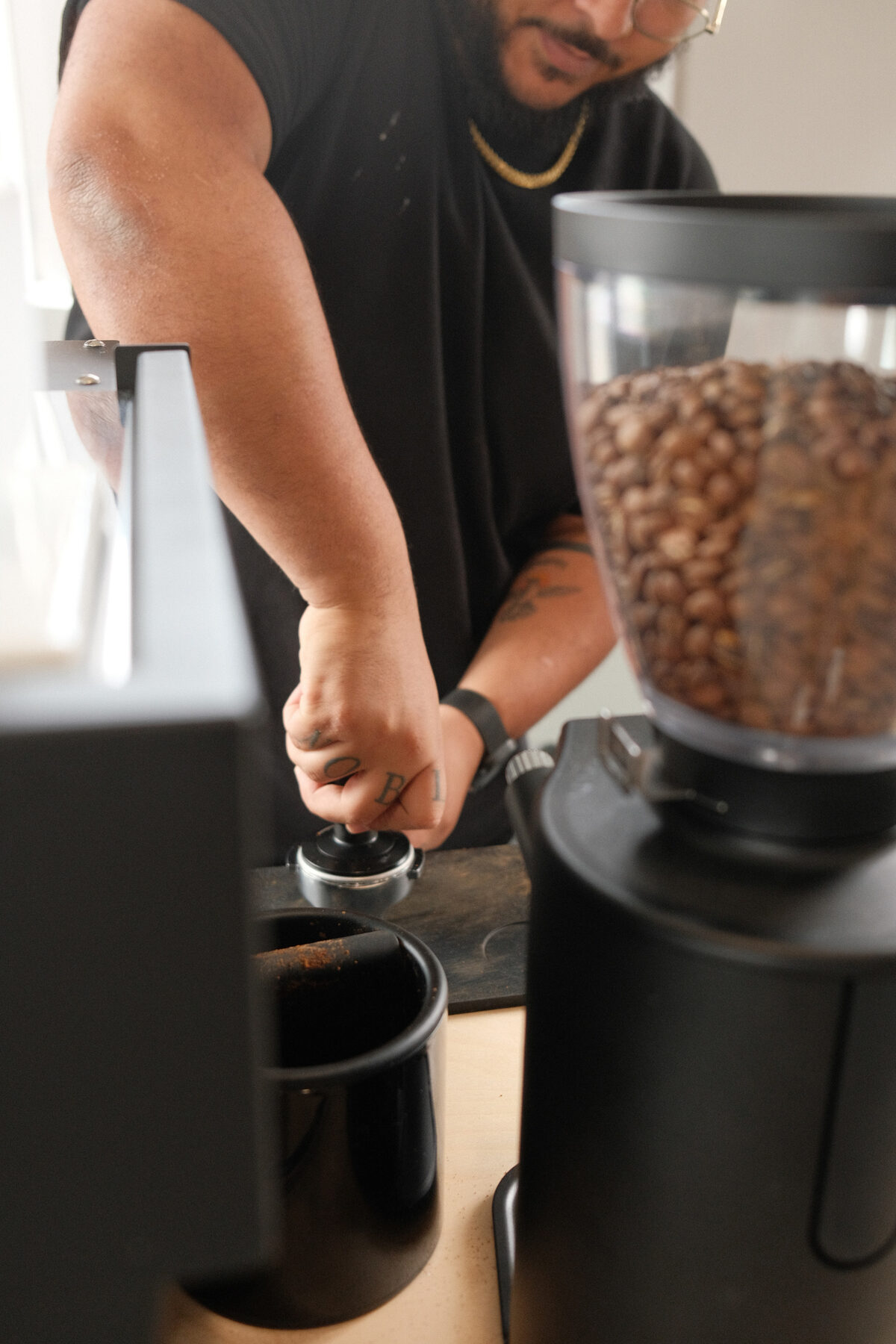 Close-up of a barista tamping espresso grounds on the Sigo cart